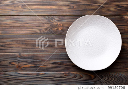 Top view of empty light plate on wooden background. Empty space for your design Top view of empty light plate on wooden background. Empty space for your design 99180706