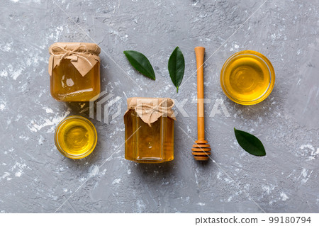 Honey jar with wooden honey dipper on white background top view with copy space. Delicious honey bottle Honey jar with wooden honey dipper on white background top view with copy space. Delicious honey bottle 99180794