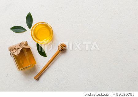 Honey jar with wooden honey dipper on white background top view with copy space. Delicious honey bottle 99180795