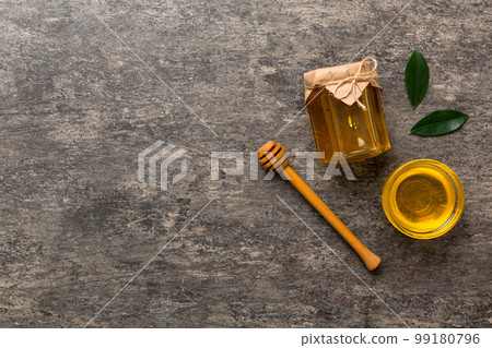 Honey jar with wooden honey dipper on white background top view with copy space. Delicious honey bottle Honey jar with wooden honey dipper on white background top view with copy space. Delicious honey bottle 99180796