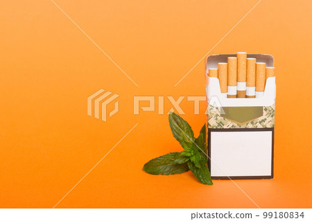 Pack of menthol cigarettes and fresh mint on colored table, Menthol cigarettes top view flat lay 99180834