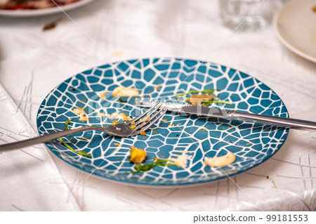 The leftover food and dirty dishes on the restaurant table. Scraps left over after the party. 99181553
