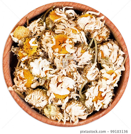 Chamomile herbal tea in a small wooden bow isolated on white. Chamomile herbal tea in a small wooden bow isolated on white. 99183136