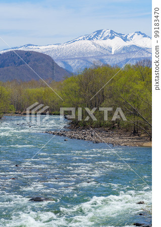 Kamikawa Town Daisetsuzan Mountain with remaining snow and Ishikari River with the melting snow 99183470