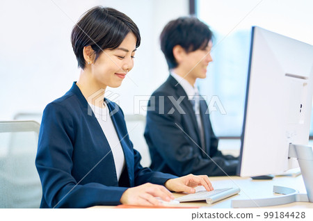 微笑的中年女商人在辦公室操作電腦 99184428