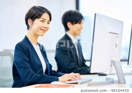 微笑的中年女商人在辦公室操作電腦 微笑的中年女商人在辦公室操作電腦 99184430