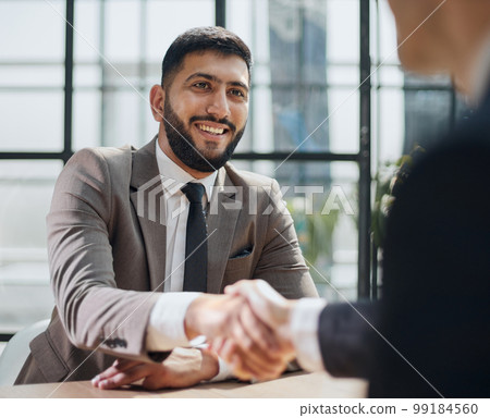 closeup of handshake of business partners in light office 99184560