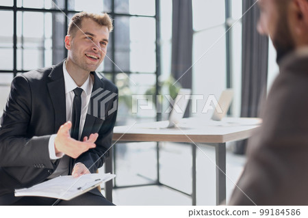 Manager interviewing a candidate in modern office Manager interviewing a candidate in modern office 99184586
