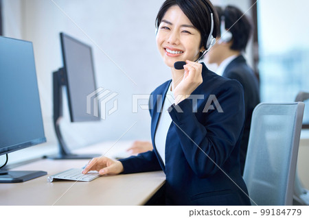 一位在辦公室戴耳機並響應的女接線員 99184779