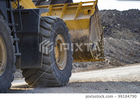 A front end loader machine tipping sand in a quarry 99184790