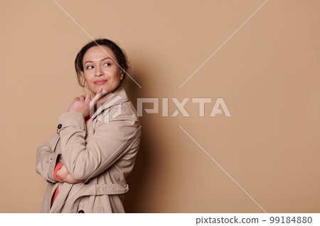 Pensive pretty woman putting index finger on her chin and dreamily looking aside, reasoning. Isolated beige abckground Pensive pretty woman putting index finger on her chin and dreamily looking aside, reasoning. Isolated beige abckground 99184880