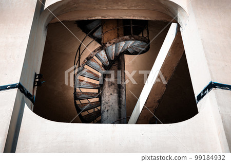 View of old metal spiral staircase inside columnar structures old water tower made of cement. Selective focus. Selective focus. View of old metal spiral staircase inside columnar structures old water tower made of cement. Selective focus. Selective focus. 99184932
