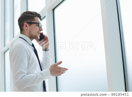 man talking on phone and smiling in office man talking on phone and smiling in office 99185451