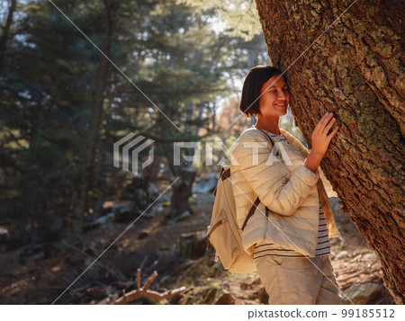 woman enjoys nature, beautiful forest in mountains woman enjoys nature, beautiful forest in mountains 99185512