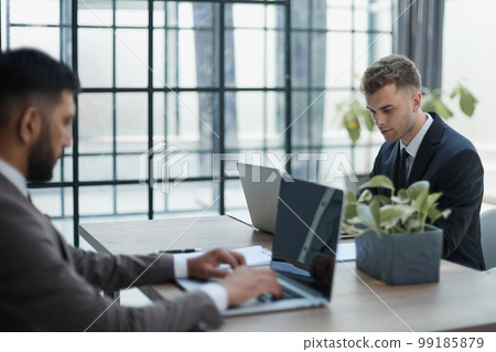 Two happy men working together on a new business project 99185879