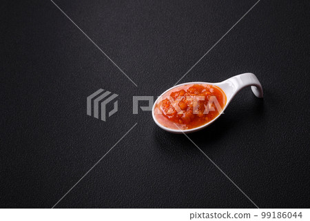 Red adjika sauce or ketchup with spices and herbs 99186044