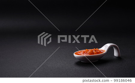 Red adjika sauce or ketchup with spices and herbs 99186046