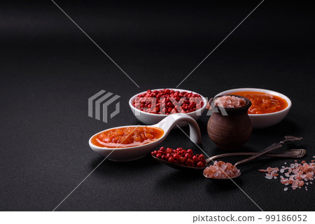Red adjika sauce or ketchup with spices and herbs Red adjika sauce or ketchup with spices and herbs 99186052