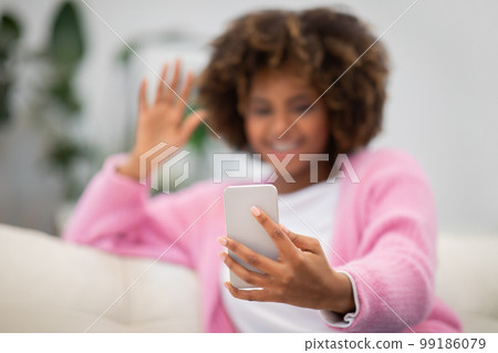Selective focus on cell phone in black woman hand 99186079