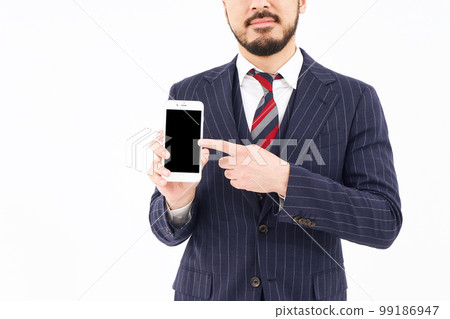 A man in a suit with a smartphone A man in a suit with a smartphone 99186947