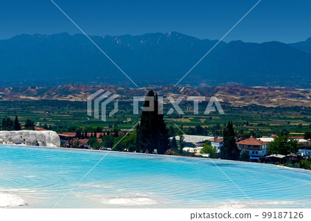 View of natural terraces in Pamukkale on a summer day. Close-up texture of limestone and water flowing over it. 99187126