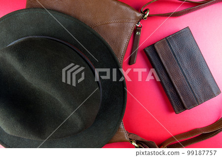 Felt Hat with Leather Bag and Leather Wallet on a Red Surface 99187757