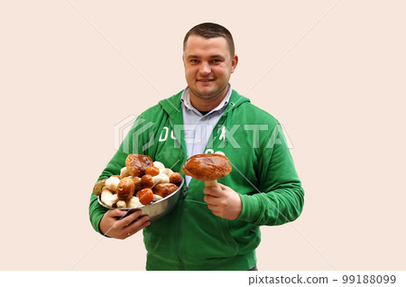 Man holding a bowl with porcini on isolated background 99188099