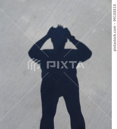 Shade Of A Man With His Hand Raised To Head  99188818