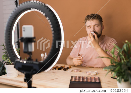 Portrait bearded man making vlog review cosmetics product and channel recording video make up tutorial making at home - Online influencer guy and social media market live steaming concept 99188964