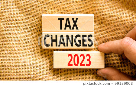 Tax changes 2023 symbol. Concept words Tax changes 2023 on wooden blocks on a beautiful canvas table canvas background. Businessman hand. Business Tax changes 2023 concept. Copy space. 99189008