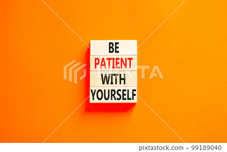 Patient with yourself symbol. Concept words Be patient with yourself on wooden blocks. Beautiful orange table orange background. Business patient with yourself concept. Copy space. 99189040