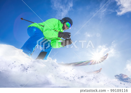 Skier skiing downhill in high mountains against against the fairytale winter forest. 99189116