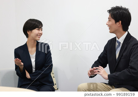 一個女商人用手勢說話,一個商人聽 1 一個女商人用手勢說話,一個商人聽 1 99189159