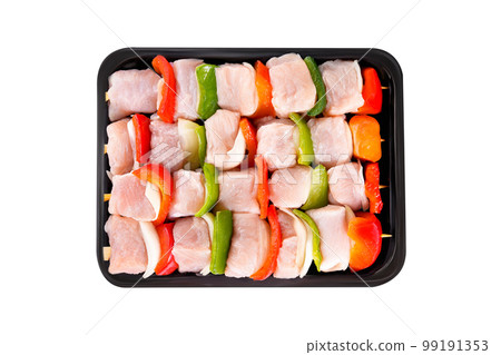 raw turkey skewers with vegetables, peppers, onions, in a tray on a white background.Skewers with pieces of raw meat, red, yellow and green pepper, on white background.Top view.Close-up. 99191353
