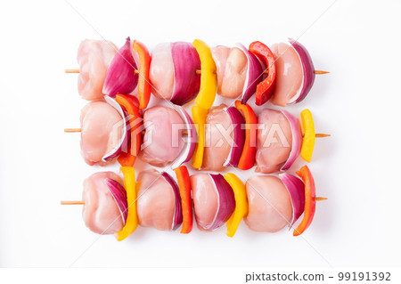 Raw chicken leg meat skewers with vegetables, peppers, onions, on a white background.Uncooked mixed meat skewer with peppers.Skewers with pieces of raw meat, red, yellow and green pepper.Top view. Raw chicken leg meat skewers with vegetables, peppers, onions, on a white background.Uncooked mixed meat skewer with peppers.Skewers with pieces of raw meat, red, yellow and green pepper.Top view. 99191392