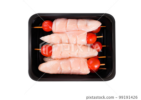 raw chicken inner on skewers with tomatoes in a tray on a white background.Close-up.Top view.Raw chicken skewers. 99191426