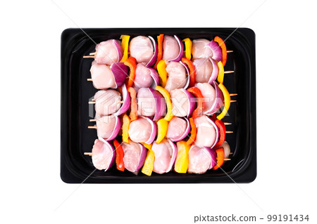 Raw chicken skewers of fillet with vegetables, plums, peppers, onions, in a tray on a white background.Skewers with pieces of raw meat, red, yellow and green pepper. Close-up.Top view. Raw chicken skewers of fillet with vegetables, plums, peppers, onions, in a tray on a white background.Skewers with pieces of raw meat, red, yellow and green pepper. Close-up.Top view. 99191434