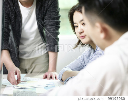 young asian business woman contemplating during meeting in office with two colleagues 99192980