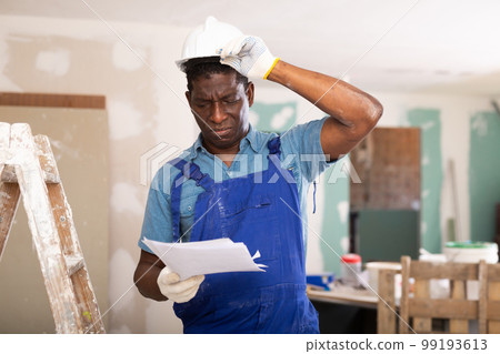 African american foreman examines documents and plans a workflow for repairs African american foreman examines documents and plans a workflow for repairs 99193613