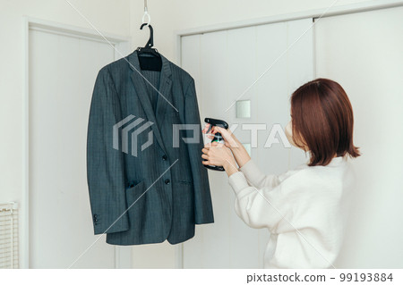在西裝上噴除臭劑的女人 99193884