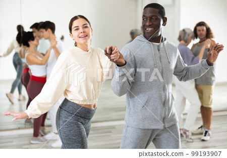 African man and caucasian lady rehearsing latin paired dance moves African man and caucasian lady rehearsing latin paired dance moves 99193907