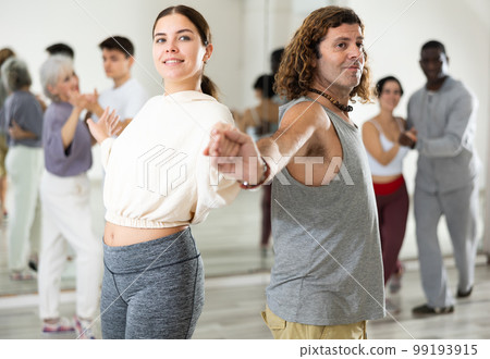 Caucasian man and lady rehearsing latin paired dance moves Caucasian man and lady rehearsing latin paired dance moves 99193915
