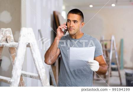 Man having telephone convesrtion in construction site 99194199