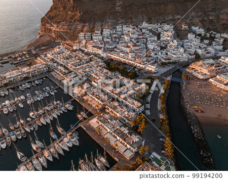 Puerto de Mogan fishing town aerial view at sunset. Traditional colorful buildings with many fishing boats at Gran Canaria, Canary Islands, Spain 99194200