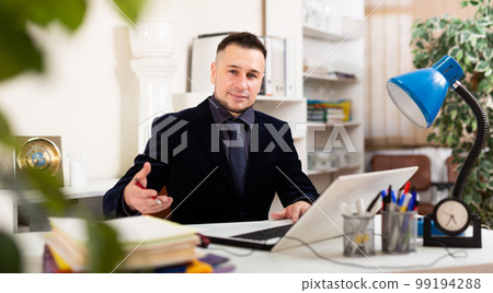 Confident young man working at office 99194288
