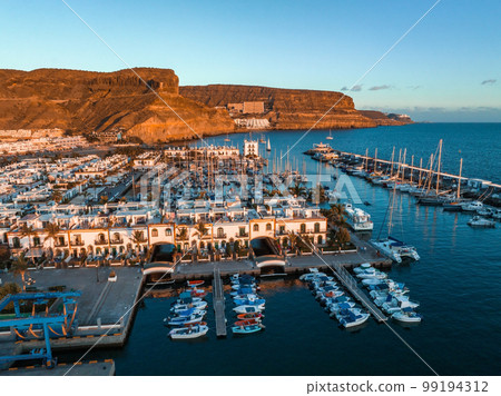 Puerto de Mogan fishing town aerial view at sunset. Traditional colorful buildings with many fishing boats at Gran Canaria, Canary Islands, Spain 99194312