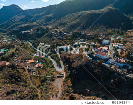 Aerial view of curvy mountain road. Cyclists riding along, getting good exercise. Cycling down curvy road. Aerial view of curvy mountain road. Cyclists riding along, getting good exercise. Cycling down curvy road. 99194374