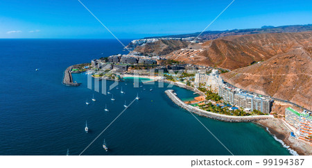 Beautiful aerial landscape with Anfi beach and resort, Gran Canaria, Spain. Luxury hotels, turquoise water, sandy beaches in Spain. Luxury beach vacation concept. Heart shaped island. Beautiful aerial landscape with Anfi beach and resort, Gran Canaria, Spain. Luxury hotels, turquoise water, sandy beaches in Spain. Luxury beach vacation concept. Heart shaped island. 99194387