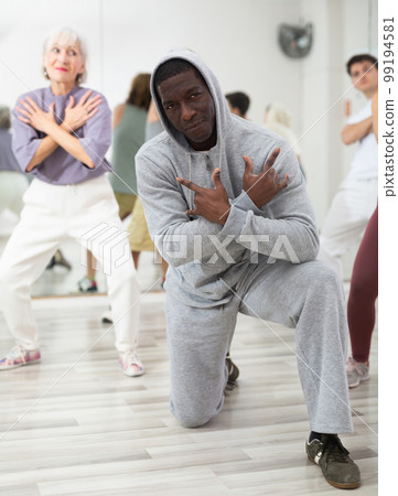 African-american man rehearsing modern hip-hop with group in dance school 99194581