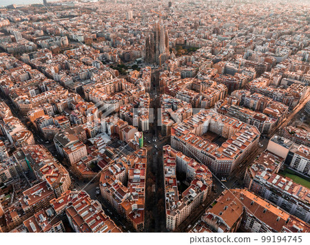 Aerial view of Barcelona City Skyline and Sagrada Familia Cathedral at sunset. Eixample residential famous urban grid. Cityscape with typical urban octagon blocks 99194745